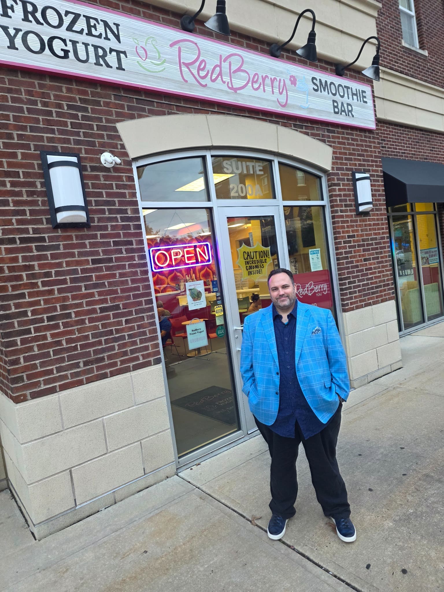 Ryan Michael Kelly standing outside RedBerry Frozen Yogurt and Smoothie Bar at TCNJ Campus Town in Ewing, New Jersey