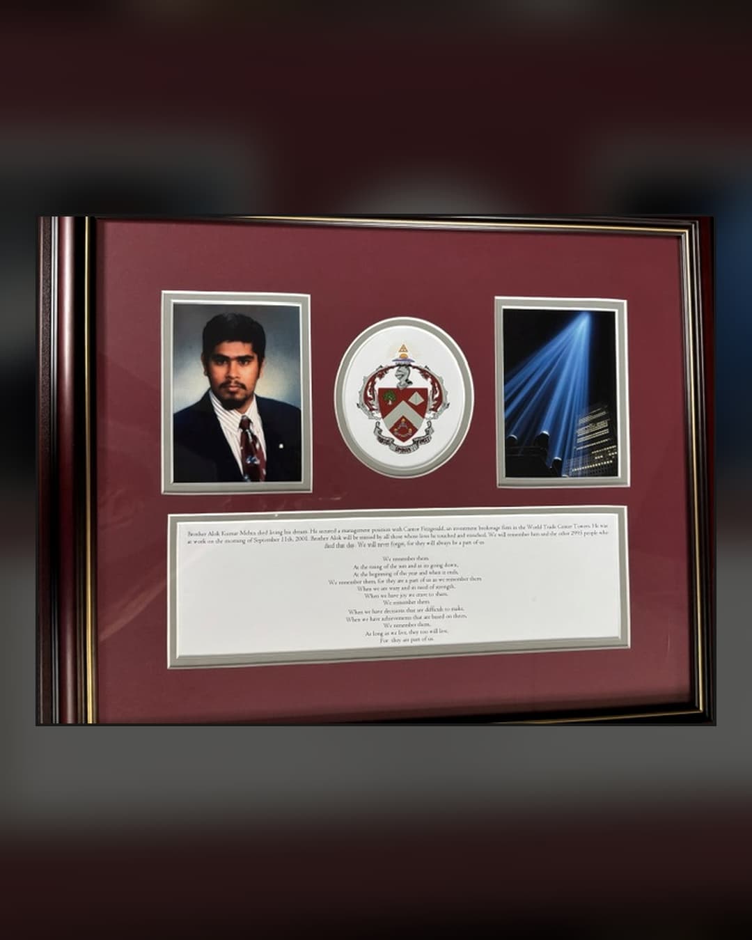 Framed memorial honoring Alok Kumar Mehta at Triangle Fraternity headquarters, featuring his portrait, the Triangle coat of arms, the Tribute in Light, and a written remembrance