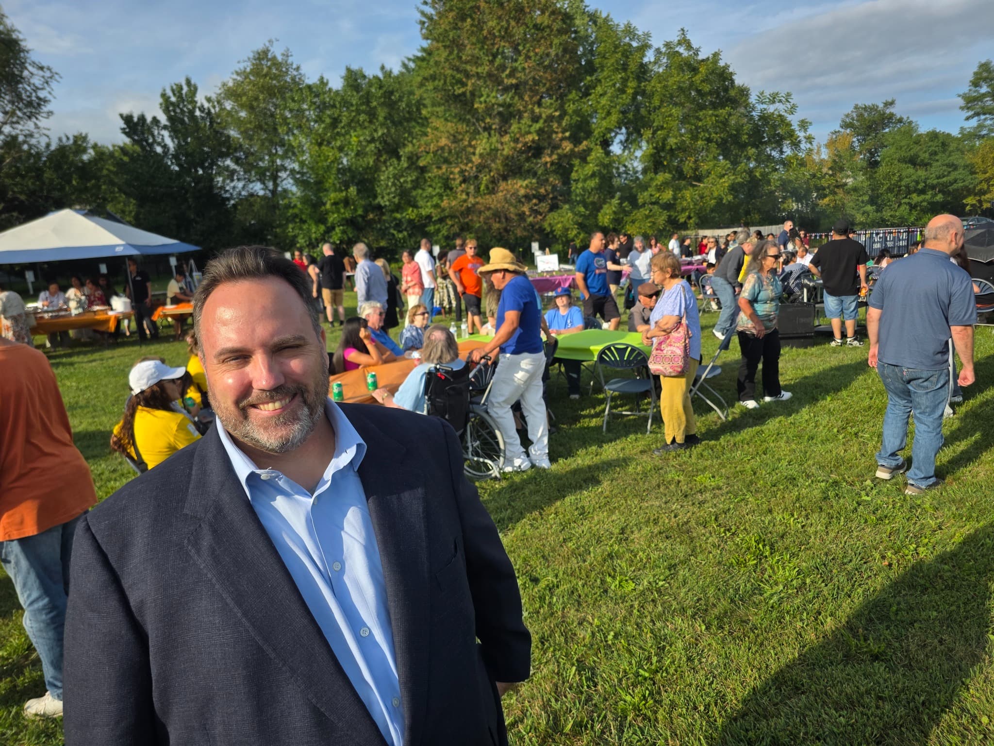 Ryan Michael Kelly attending the outdoor Multicultural Festival at St. Anthony of Padua in Hightstown, with neighbors and festival activities in the background
